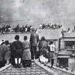 浅草の大火を屋根の上から見物する人々<br>People watching the spread of fires in Asakusa on 6 April 1921