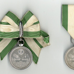 Imperial reconstruction commemorative brooch for women (left) and men (right)<br>Source: 帝都復興記念章, 1930