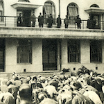 大震災焼失小学校代表職員及び生徒に御親閲を賜う<br>Following lunch on the rooftop of Chiyoda Primary School, the Emperor stepped onto the second-floor balcony overlooking the sports ground where 474 children and 412 dignitaries, city officials and teachers were gathered to greet him. School children and teachers from schools that were destroyed by the earthquake and fires were invited to the ceremony. The Emperor spent ninety minutes at Chiyoda Primary School, more than any other location on his tour of the reconstructed capital.<br>Source: 帝都復興祭志, 1932