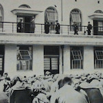 千代田小学校校庭に於ける罹災区代表児童の奉迎<br>Children representing schools that were destroyed in the earthquake and fires assembled on the sports ground of Chiyoda Primary School and bowed when the Emperor appeared on the second floor balcony.<br>Source: 復興記念日本橋区, 1930